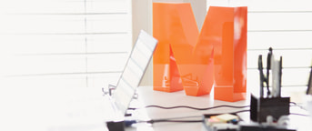 Oranges M auf Bürotisch Oranges M auf Bürotisch